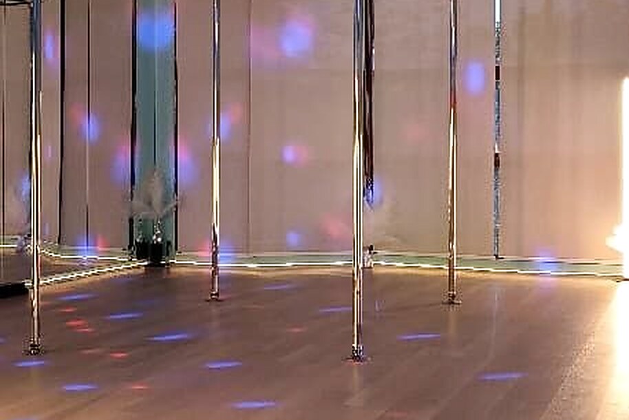 The Saint Room: a bright studio with a vinyl floor, mirrors and chrome poles